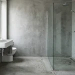Salle de bain moderne béton ciré : signes d'humidité et d'usure près de la douche.